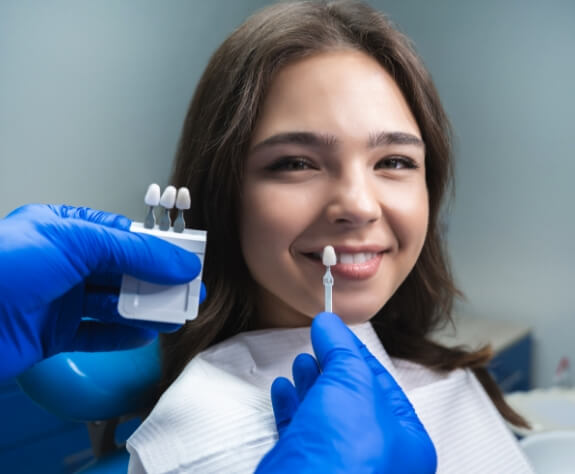 Cosmetic dentist comparing smile to veneers color option