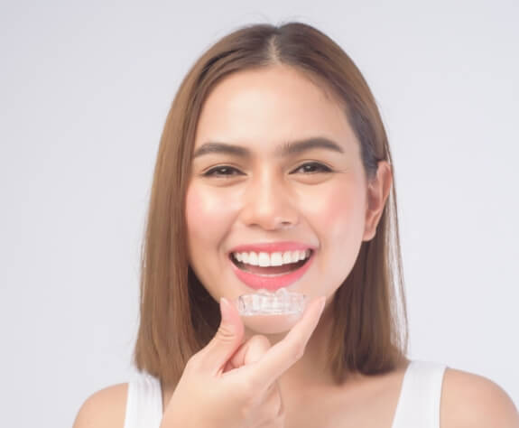 Dental patient placing an Invisalign clear braces tray