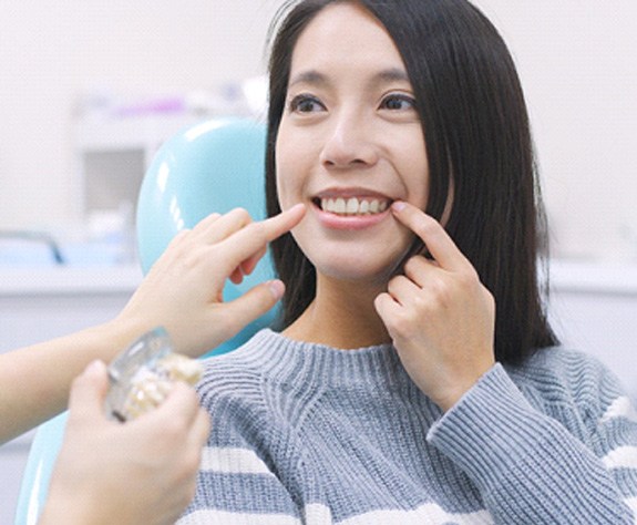 A smiling woman chatting with her dentist