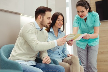 Dental team member showing financial brochure