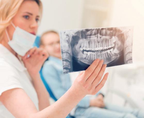 Dentist reviewing a dental X-ray with her patient