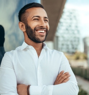 Man in white collared shirt smiling outdoors