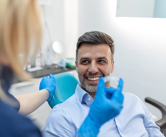 Patient and dental team member having friendly conversation