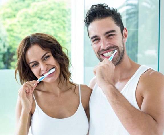 Couple brushing teeth in Raleigh