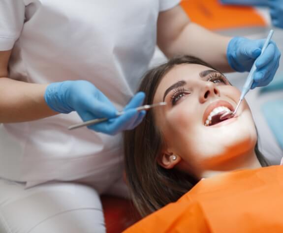 Woman receiving a preventive dentistry checkup and teeth cleaning