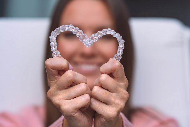 person holding Invisalign aligners