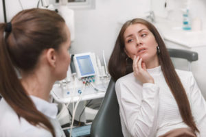 Female patient with dental pain speaking with dentist